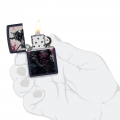 zapalniczka benzynowa Zippo w dłoni w ciemnym kolorze odpalona zapalniczka benzynowa Zippo w dłoni w ciemnym kolorze odpalona