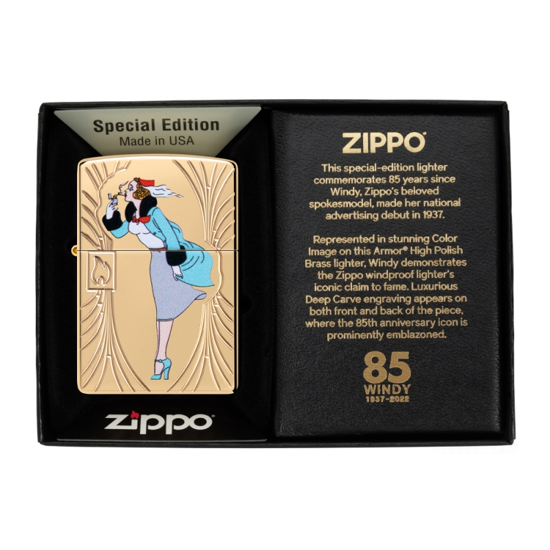 Zippo w pudełku z eleganckim metalicznym połyskiem i barwnym obrazem Windy który wyróżnia się na tle opakowania