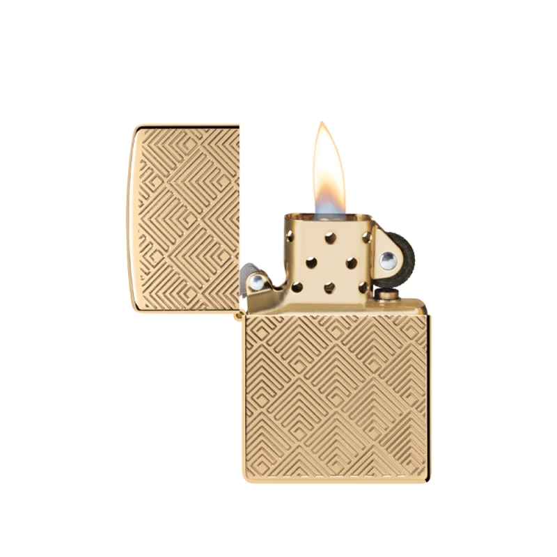 odpalona zapalniczka z jasnym płomieniem nad złotym tłem bogato zdobionym geometrycznym wzorem