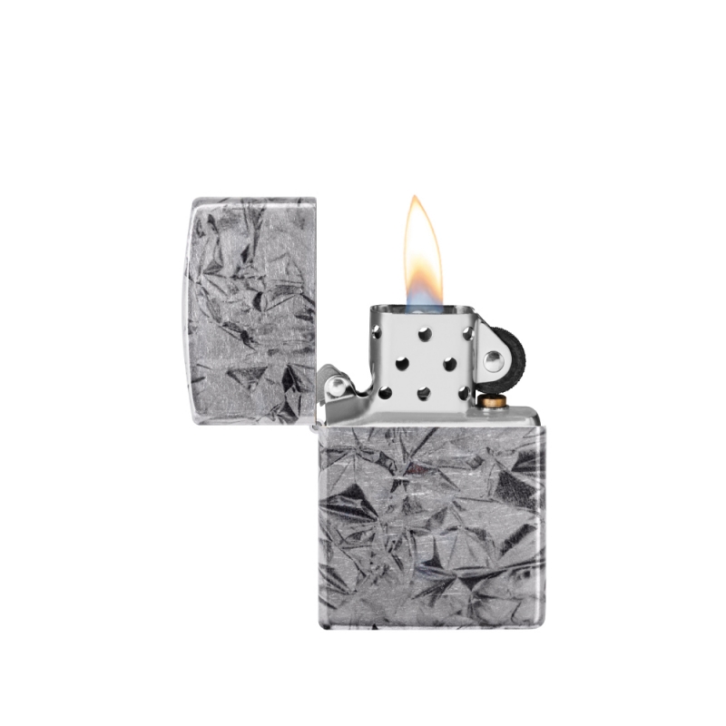 odpalona zapalniczka z wyraźnym płomieniem nad metaliczną powierzchnią z efektem aluminium foil