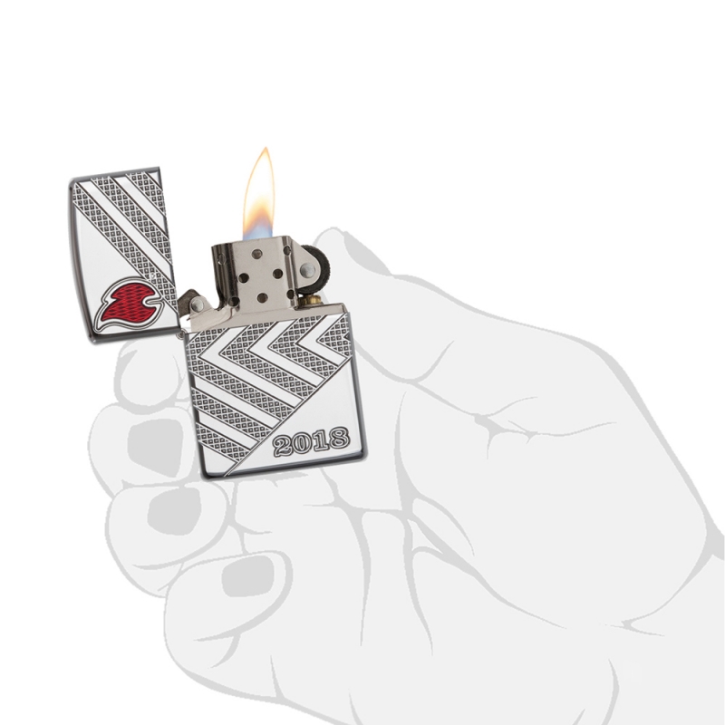 zapalniczka trzymana w dłoni pokazuje kompaktowy rozmiar i elegancki chromowany design z grawerowanymi liniami