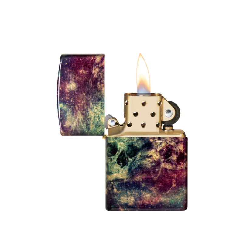 odpalona zapalniczka z wyraźnym płomieniem nad metaliczną powierzchnią z kosmicznym motywem czaszek