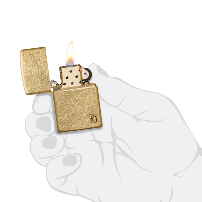 zapalniczka trzymana w dłoni pokazuje solidny rozmiar i eleganckie wykończenie starzonego mosiądzu z detalem płomienia