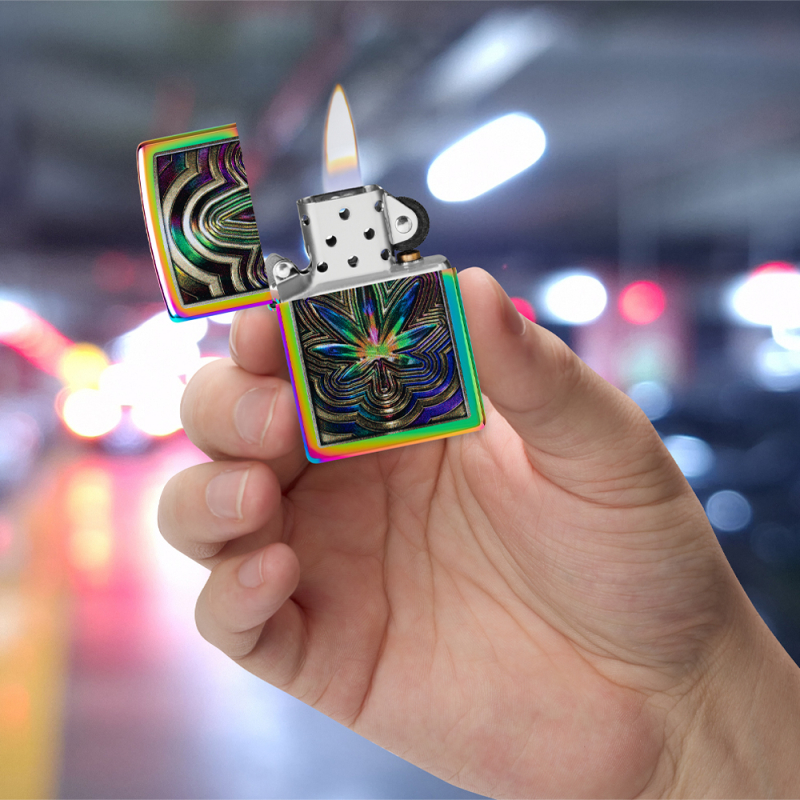 Psychodeliczna zapalniczka Zippo trzymana w dłoni z kolorowym wzorem Metallic Leaf na obudowie