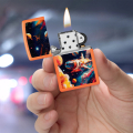 Pomarańczowa zapalniczka Zippo trzymana w dłoni z kolorową grafiką kosmosu na obudowie
