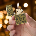 Postarzane złote Zippo z motywem płomienia widoczne w dłoni