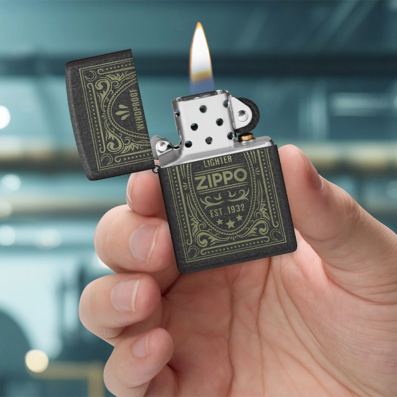 Czarna obudowa Zippo z kontrastowymi napisami widoczna w dłoni