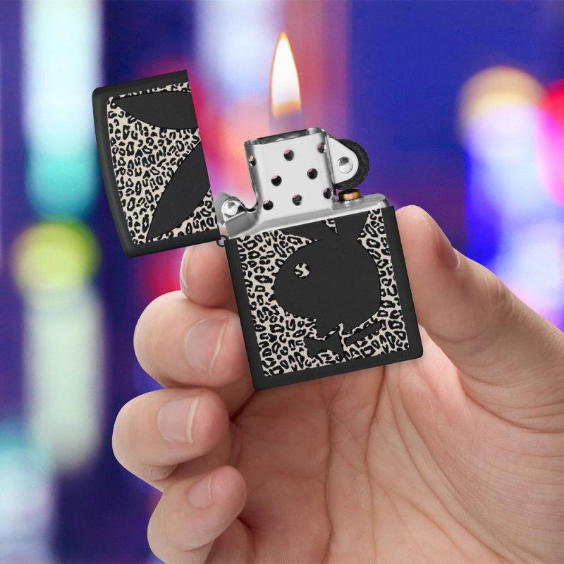 Zippo z czarnym logo Playboy na panterkowym tle trzymana w ręce
