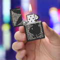 Zippo z czarnym logo Playboy na panterkowym tle trzymana w ręce